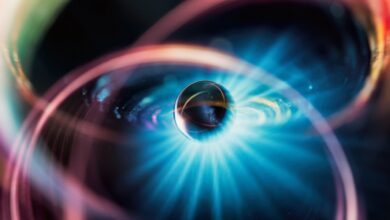 An illustration of a metal sphere surrounded by various colors and a glow of blue light.