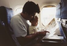 a father hold his infant son on an airplane