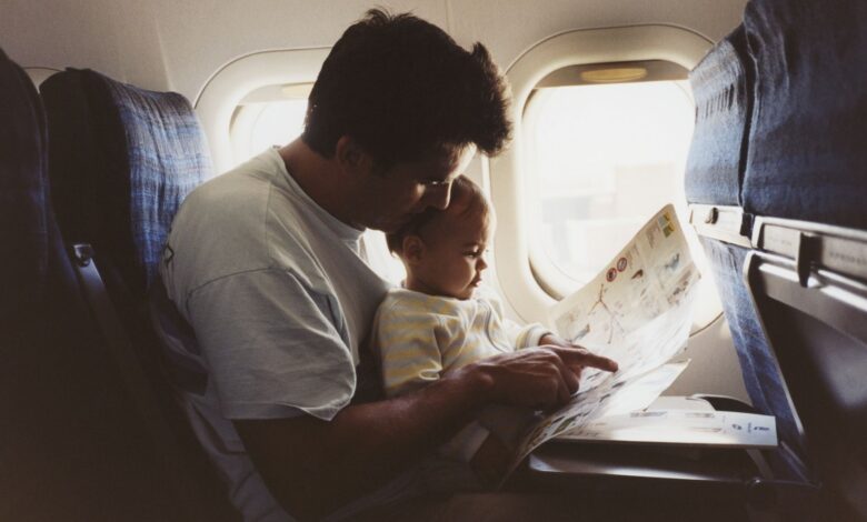 a father hold his infant son on an airplane